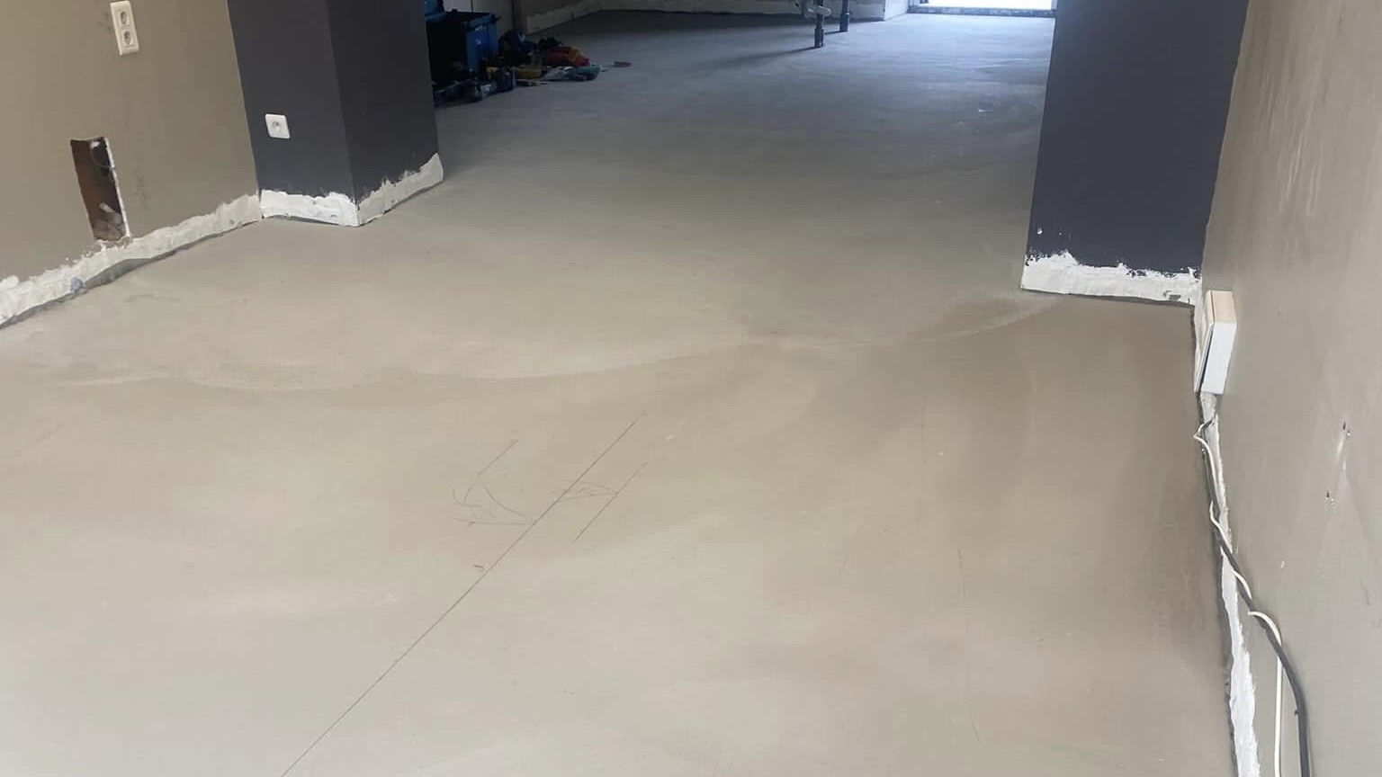 Travaux de ragréage au sol avec plaque de protection sur surface plane et uniforme