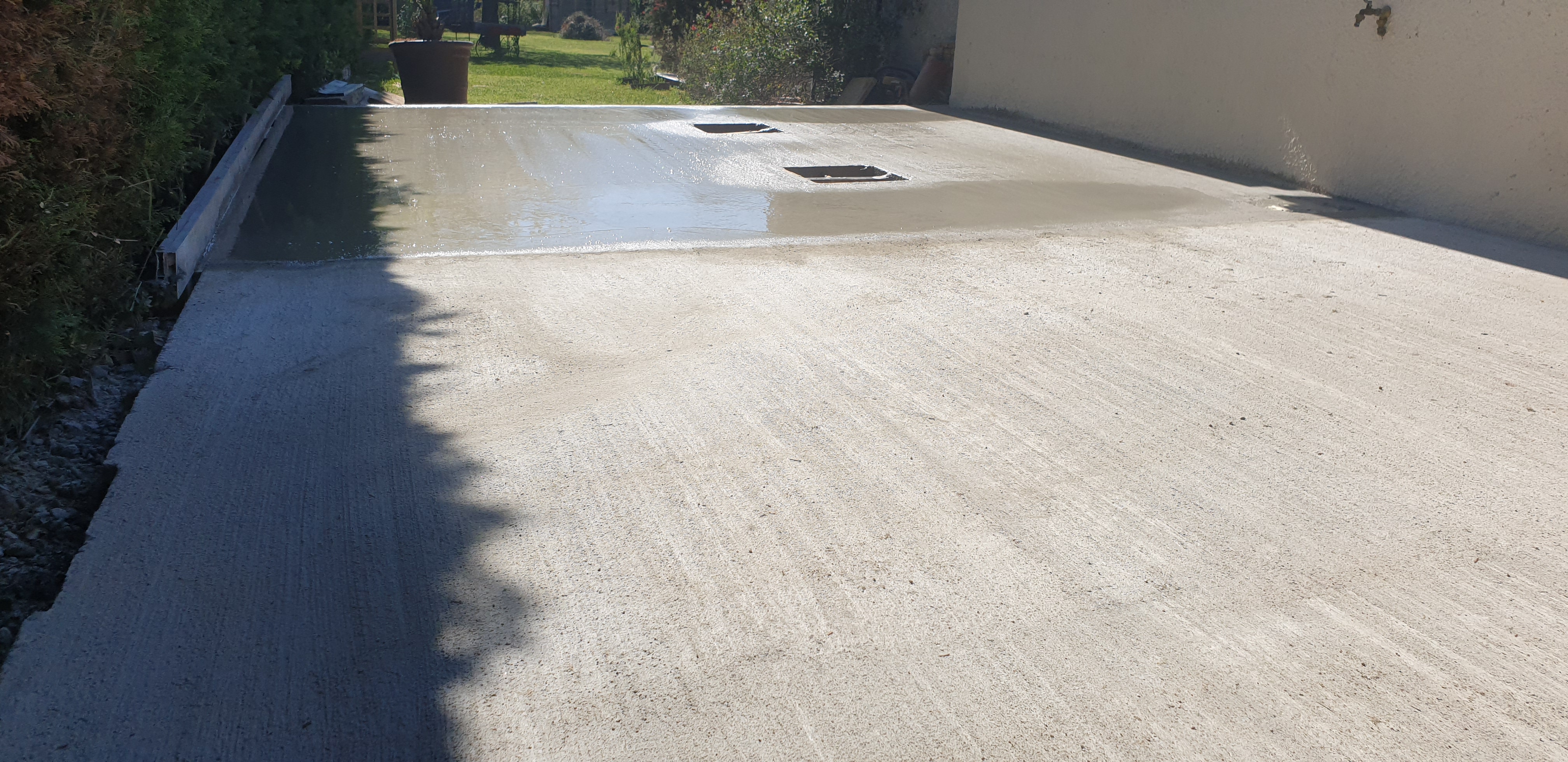 Dalle béton extérieure fraîchement coulée avec réservations pour évacuations à Toulouse