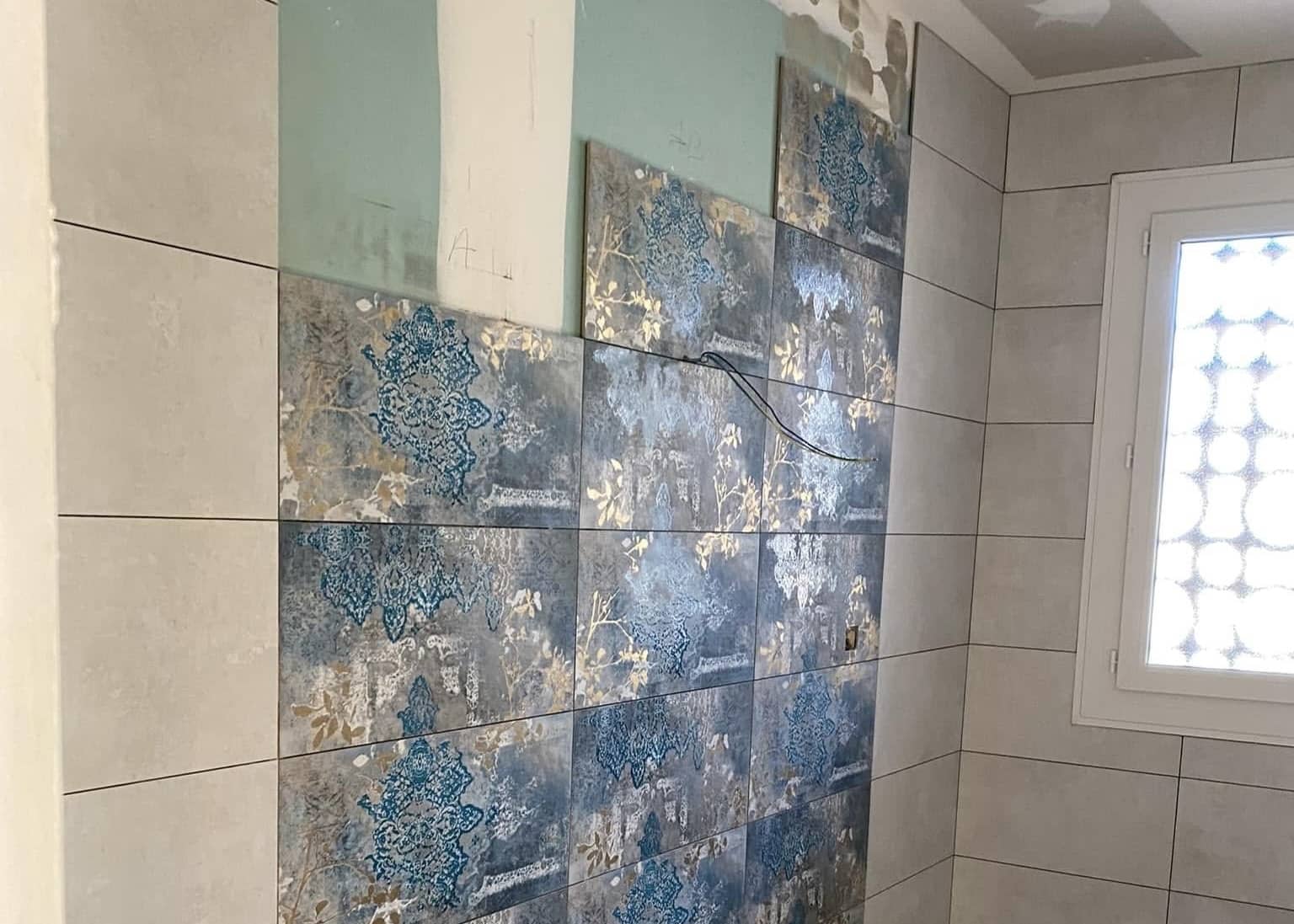 Salle de bain avec faïence murale décorative style mosaïque et cloison en briques de verre