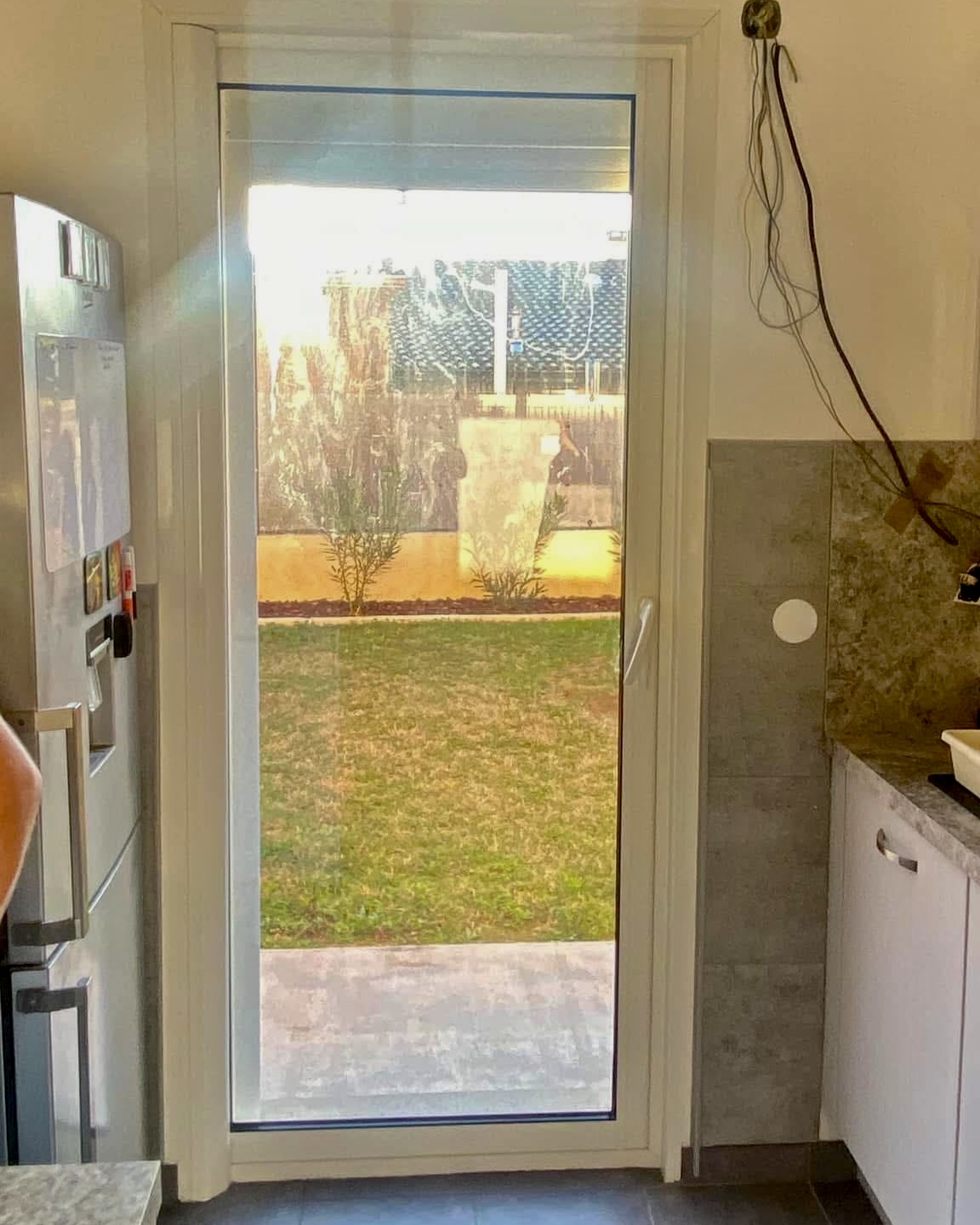 Baie vitrée coulissante PVC posée dans une cuisine avec accès au jardin
