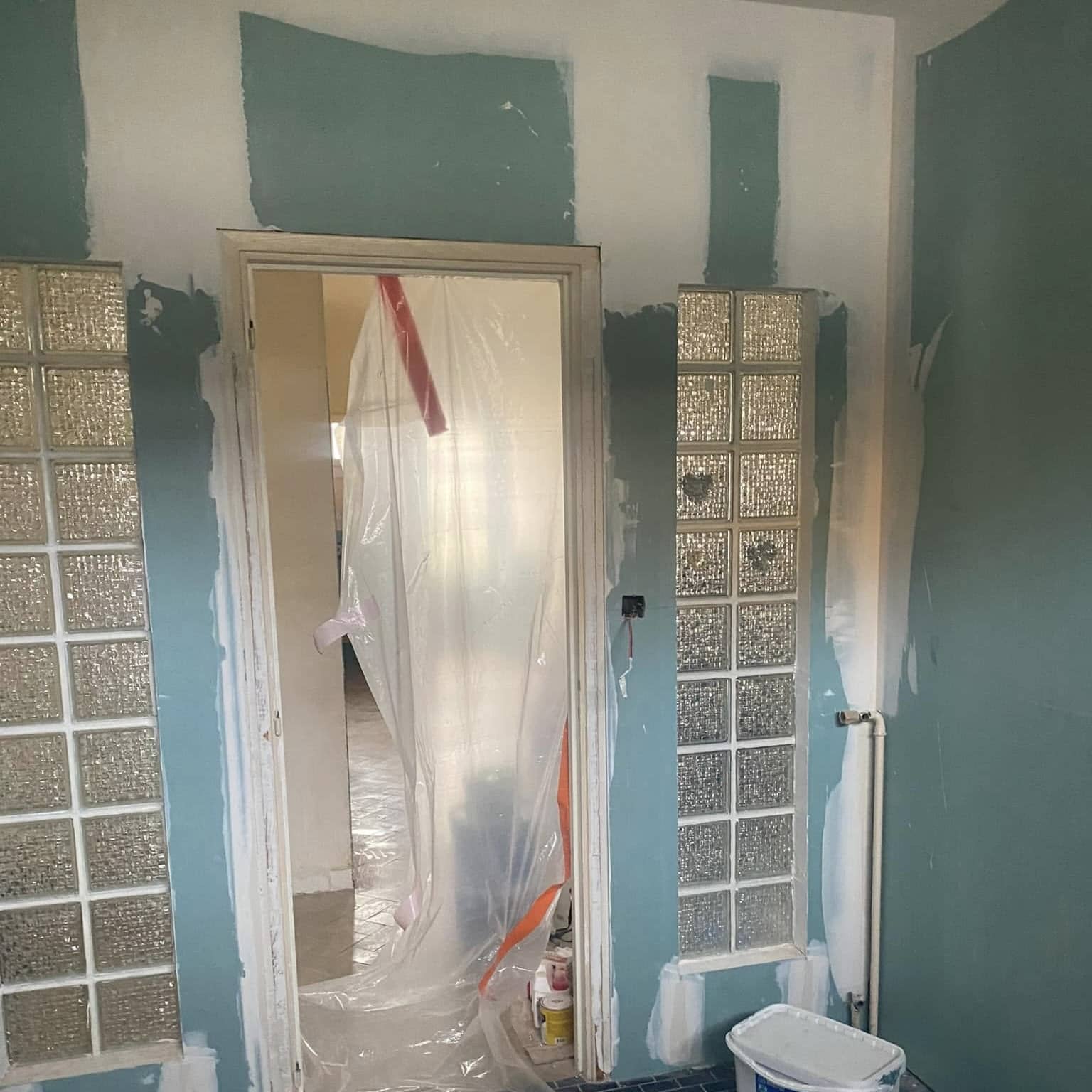 Travaux de rénovation intérieure avec pose de plaques de placo et enduit, encadrement de porte et briques de verre