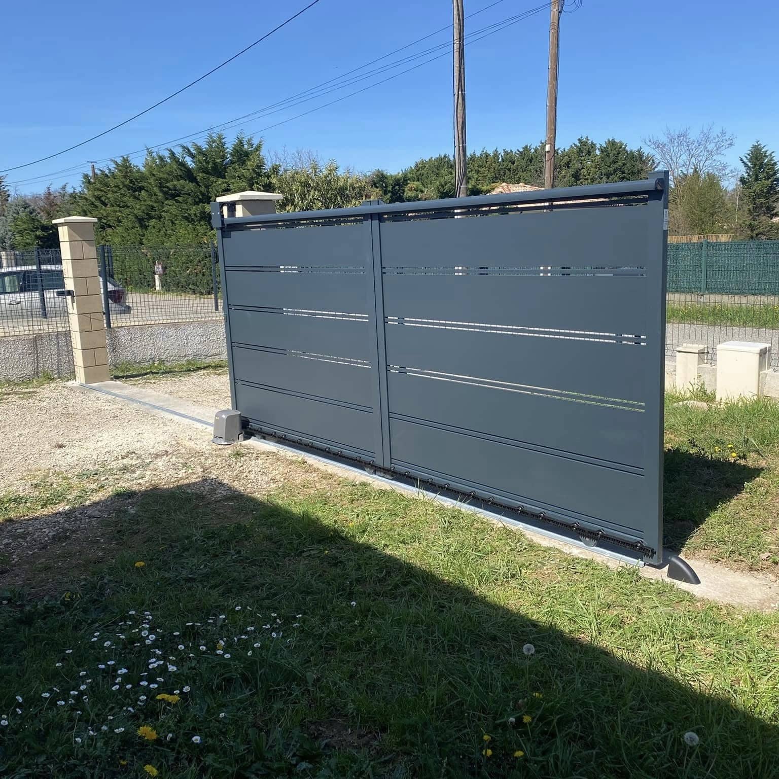 Portail coulissant en aluminium gris anthracite avec motorisation, vue de l’intérieur du jardin
