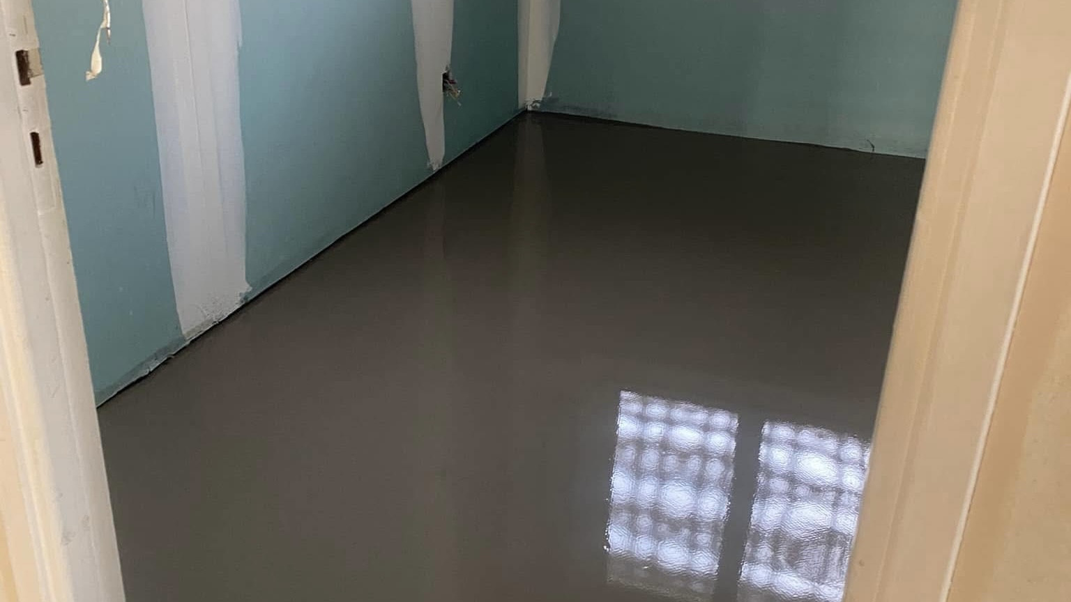 Sol fraîchement ragréé avec finition lisse dans une pièce en cours de rénovation